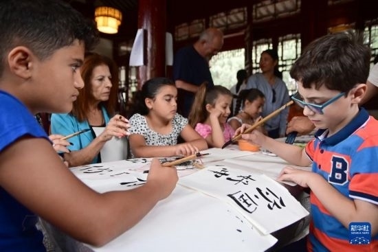 7月4日，在馬耳他桑塔露琪亞市的中國古典園林“靜園”，人們體驗中國書法。新華社發(fā)（喬納森·博格 攝）