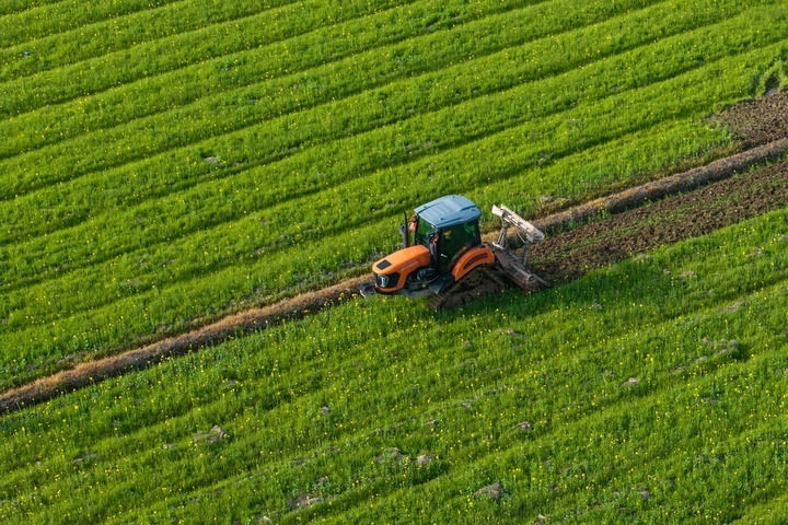 2024年3月19日，在湖南省常德市鼎城區(qū)謝家鋪鎮(zhèn)港中坪村，村民駕駛農(nóng)機(jī)翻耕田地（無(wú)人機(jī)照片）。新華社記者 陳思汗 攝