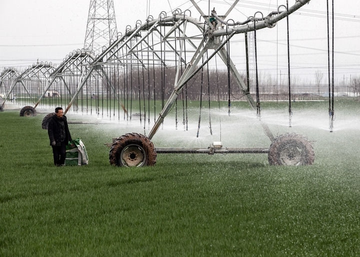 2024年3月18日，在河南省焦作市博愛(ài)縣孝敬鎮(zhèn)東原莊村瑞輝家庭農(nóng)場(chǎng)，村民使用全自動(dòng)指針式噴灌機(jī)進(jìn)行澆灌作業(yè)。新華社發(fā)（程全攝）