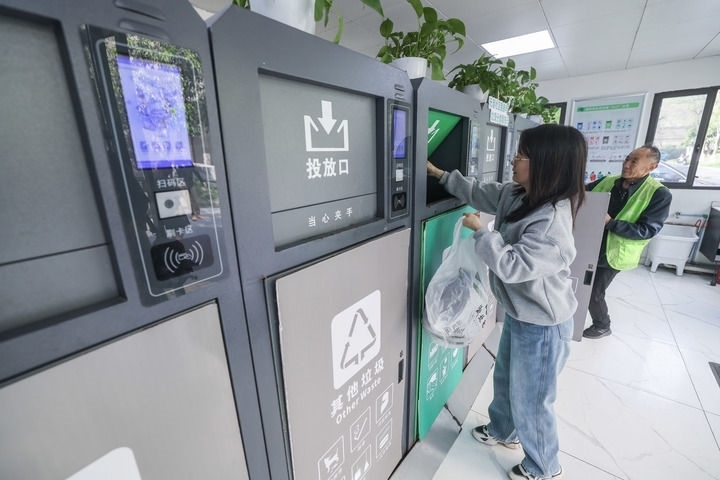 2024年4月10日，在浙江省湖州市吳興區(qū)飛英街道新華府小區(qū)內(nèi)，居民在垃圾分類智能系統(tǒng)的指導(dǎo)下進(jìn)行垃圾分類投放，居民的投放情況將實(shí)時(shí)匯總到智慧服務(wù)平臺(tái)，會(huì)有相應(yīng)的積分獎(jiǎng)勵(lì)。新華社記者 徐昱 攝