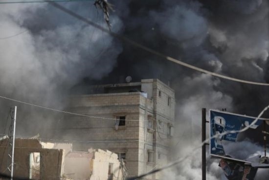 7月21日，在加沙地帶中部的努賽賴特難民營，遭以軍空襲的建筑冒出滾滾濃煙。新華社發(fā)（馬爾萬·達(dá)烏德攝）