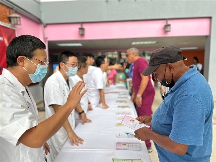 援圭醫(yī)療隊(duì)隊(duì)員們在啟動(dòng)儀式上為當(dāng)?shù)孛癖姺职l(fā)宣傳手冊。中國援助圭亞那醫(yī)療隊(duì)供圖