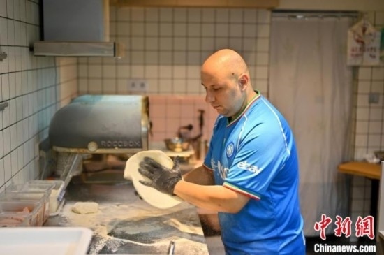 近日，韋榮耀在自家披薩小店內(nèi)忙活。俞靖 攝