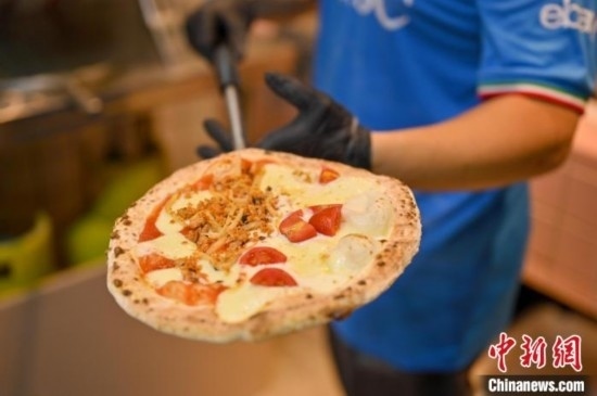 近日，韋榮耀展示他制作的“老友味”披薩。 俞靖 攝