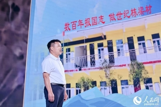 張玉滾分享用一根扁擔(dān)送孩子們走出大山的故事。人民網(wǎng)攝