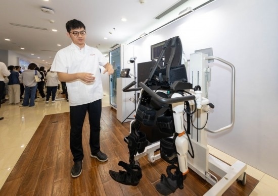 2024年5月24日，在位于上海市嘉定區(qū)的上海交通大學醫(yī)學院附屬瑞金醫(yī)院腫瘤質(zhì)子中心，工作人員介紹由瑞金醫(yī)院醫(yī)生和醫(yī)療公司共同研發(fā)的用于恢復患者下肢的醫(yī)療機器人。新華社記者 王翔 攝