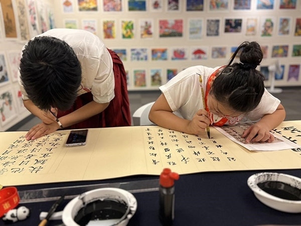參加本次展覽的青少年在現(xiàn)場進行書法創(chuàng)作。主辦方供圖