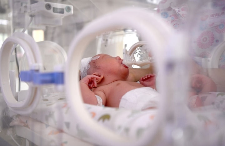 2024年6月1日，在西安國(guó)際醫(yī)學(xué)中心醫(yī)院新生兒科病房，護(hù)士為新生兒喂奶。 新華社記者 劉瀟 攝