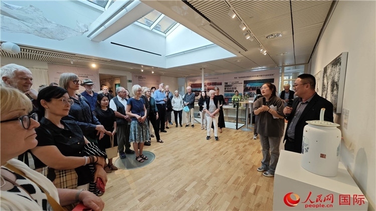 參展人、景德鎮(zhèn)陶瓷大學美術學院副院長邵長宗（右一）向來賓介紹參展作品。人民網(wǎng)記者 殷淼攝