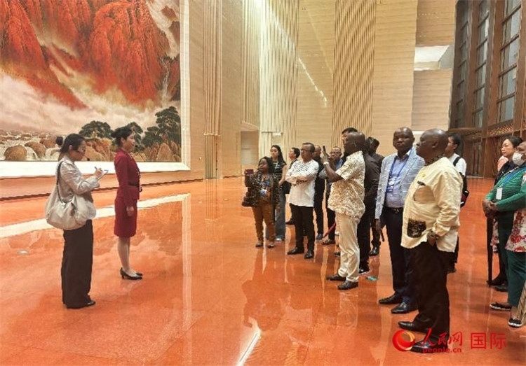 代表團(tuán)在入口處聽取講解。人民網(wǎng) 曹欣悅攝