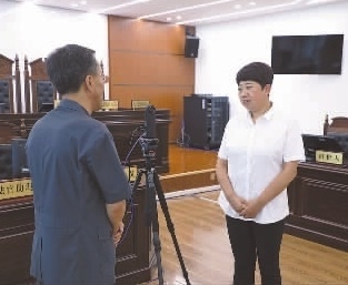 圖為全國人大代表玉明姬（右）詳細(xì)了解環(huán)境資源審判工作情況。劉思妤 攝