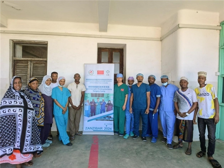 隊長蔣國慶（右七）和手術醫(yī)生、部分患者合影。中國援桑醫(yī)療隊供圖