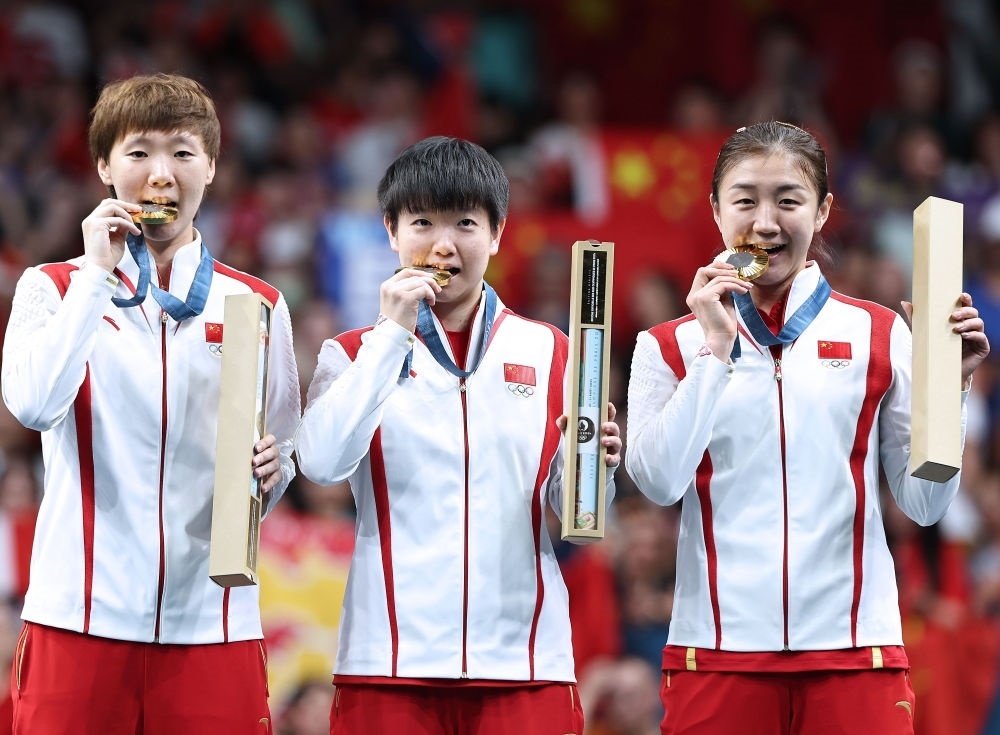 冠軍中國隊選手王曼昱、孫穎莎、陳夢（從左至右）在巴黎奧運會乒乓球女子團體頒獎儀式上（2024年8月10日攝）。新華社記者 王東震 攝