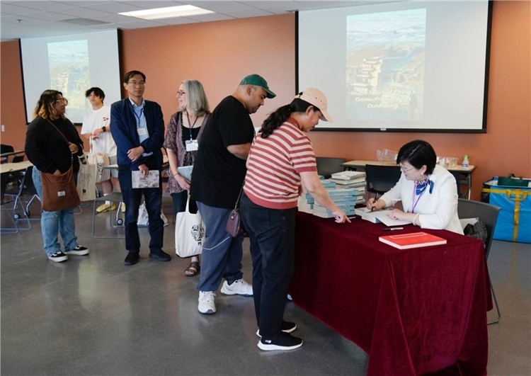 作者顧春芳在活動現(xiàn)場簽名贈書。羅先勇攝