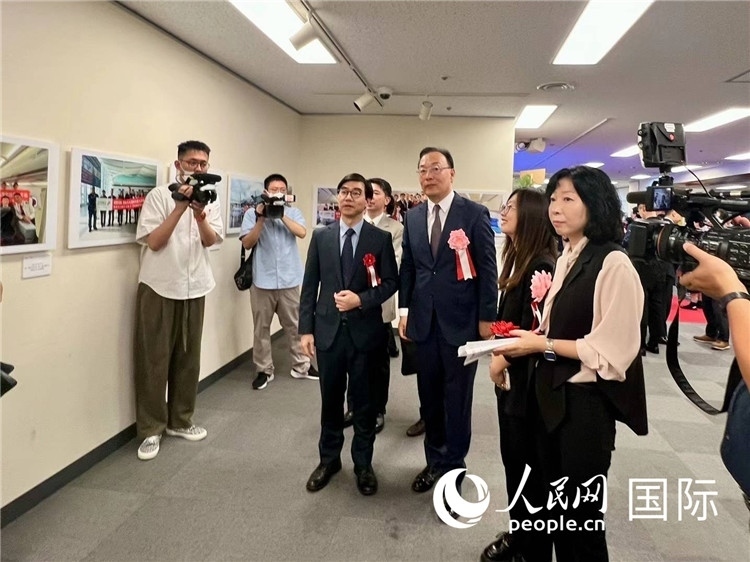 中國(guó)國(guó)際航空日韓地區(qū)支社支社長(zhǎng)馮力為中國(guó)駐日本大使館臨時(shí)代辦施泳等嘉賓介紹展出圖片。人民網(wǎng) 許可攝