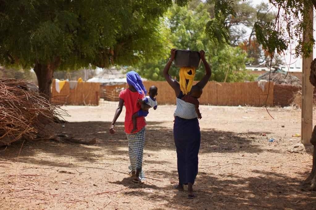 2023年3月20日，在塞內(nèi)加爾久爾貝勒區(qū)的泰內(nèi)富勒村，村民將取到的水運(yùn)回家。新華社記者 王子正 攝