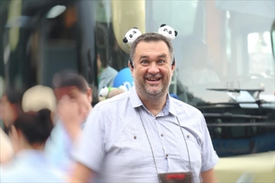 參訪熊貓谷前，塞爾維亞“一帶一路”研究所所長(zhǎng)博揚(yáng)·拉利奇戴上熊貓頭飾。（李佩藺 攝）