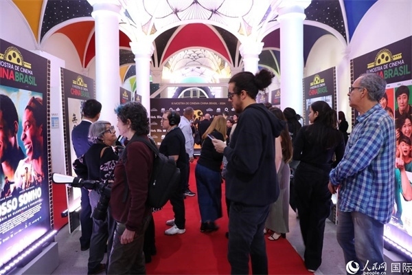 為期4天的第三屆中國(guó)－巴西電影展期間，來(lái)自中巴兩國(guó)的14部參展影片受到巴西電影愛(ài)好者和社會(huì)各界人士好評(píng)，圖為當(dāng)?shù)赜^眾在影展舉辦地巴西里約熱內(nèi)盧勞拉—阿爾維姆文化之家的迎賓廳欣賞參展電影海報(bào)。 人民網(wǎng)記者 陳一鳴攝