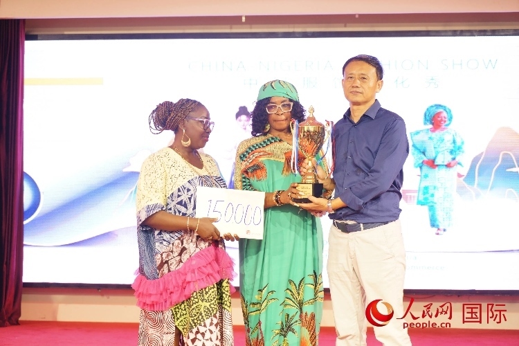 中國(guó)駐尼日利亞使館文化參贊兼中國(guó)文化中心主任李旭大（右）為最佳表現(xiàn)獎(jiǎng)?lì)C獎(jiǎng)（中）。人民網(wǎng)記者 姜宣攝