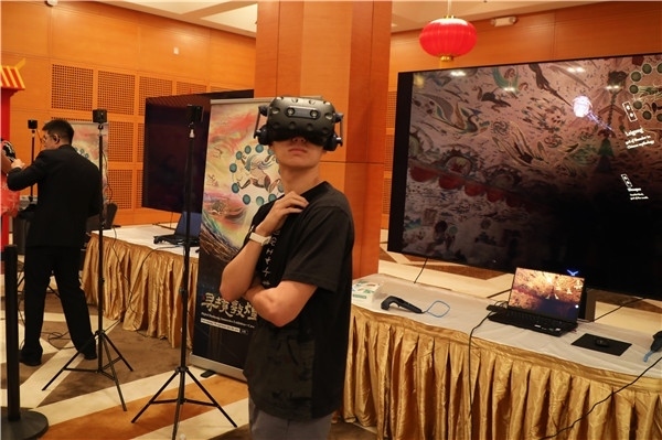 1、在本次活動的展覽現(xiàn)場，敦煌研究院與騰訊展示了“數(shù)字藏經(jīng)洞”和“尋境敦煌”等創(chuàng)新互動產(chǎn)品。圖為當?shù)孛癖娡ㄟ^VR虛擬游覽洞窟。 人民網(wǎng)記者 李志偉攝