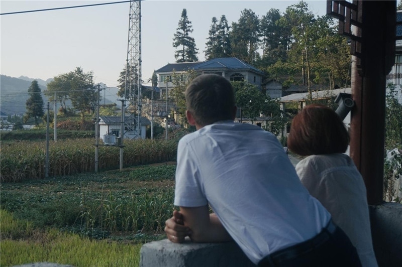 望得見山，看得見水，記得住鄉(xiāng)愁。每個人心中都有一個屬于自己的“花茂村”，在這方心田，走遍千山萬水，鄉(xiāng)音未改鬢毛衰。吉爾吉斯斯坦《比什凱克晚報》第一副總編輯妮娜·尼奇博洛娃與《中國與俄羅斯》雜志社社長奧列格·別列日內赫攝在花茂村民居屋檐下并肩佇立，眺望山水，尋覓鄉(xiāng)愁。（李光裕攝）