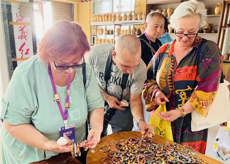 歐亞媒體考察團成員在母氏陶藝館內挑花了眼，色彩絢麗、質地均勻的陶藝手串讓他們愛不釋手?！斑@里的東西都太實惠了！”塔吉克斯坦《索格特真理報》政論部主任娜塔利婭·多羅費耶娃說?；宓奶厣a(chǎn)品物美價廉，讓考察團成員為家人好友買到了心儀的禮物，也為此次以四川成都為起點，路經(jīng)南充、廣安至貴州遵義的考察行程畫上了圓滿句號。（張亞欣攝）