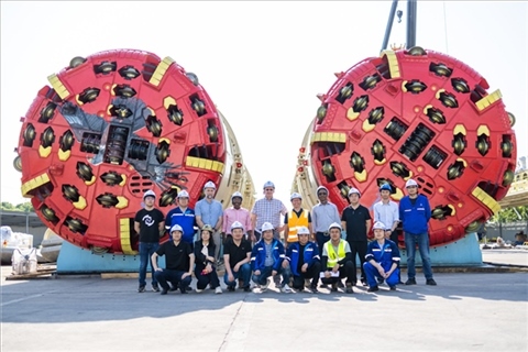 中外員工在盾構(gòu)機(jī)前合影。中國電建供圖