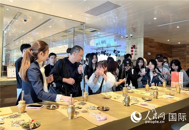 1. 日中友好協(xié)會青年代表團(tuán)一行學(xué)習(xí)中醫(yī)香囊制作工序。（人民網(wǎng)記者陳思 攝）