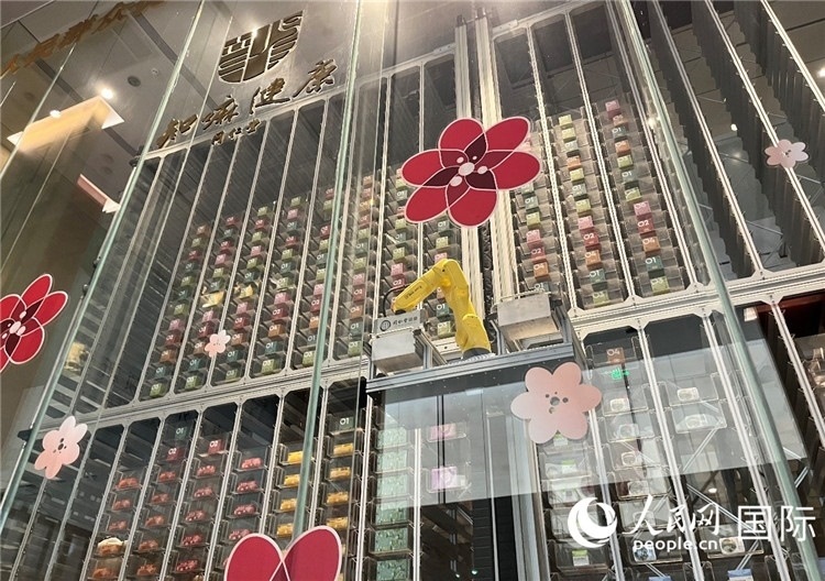 6. 機(jī)械臂正在取貨。（人民網(wǎng)記者陳思 攝）