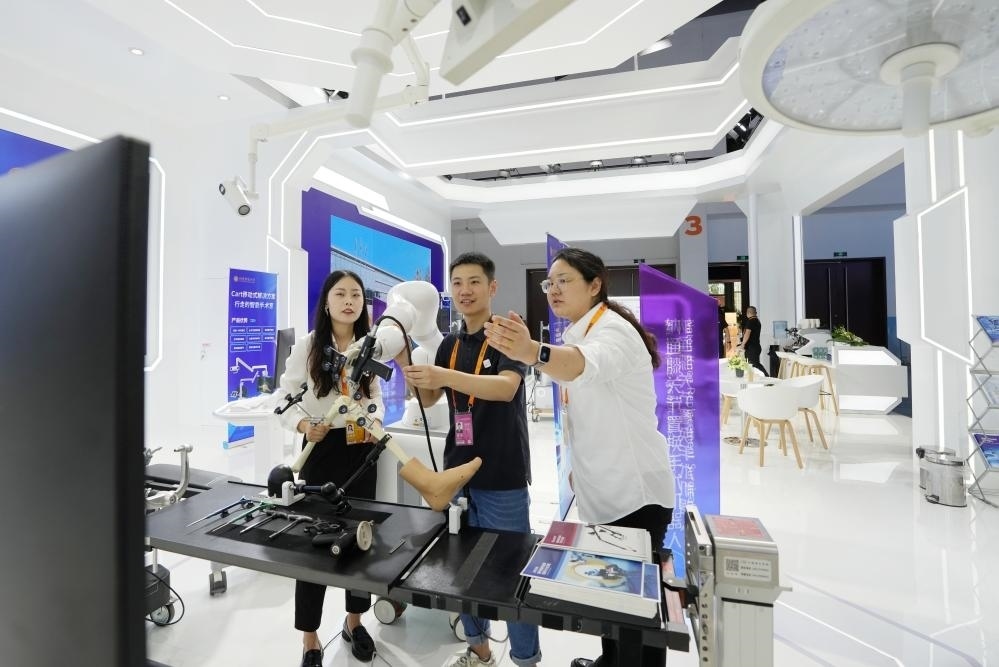 9月11日，一位媒體記者（中）在2024年服貿(mào)會(huì)國(guó)家會(huì)議中心會(huì)場(chǎng)體驗(yàn)北京納通科技集團(tuán)有限公司的膝關(guān)節(jié)置換手術(shù)機(jī)器人。新華社記者鞠煥宗 攝