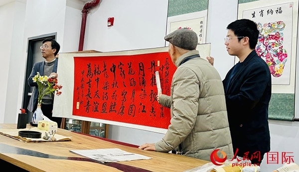 旅秘書法家向現(xiàn)場觀眾展示書法作品。人民網(wǎng)記者 宋亦然攝