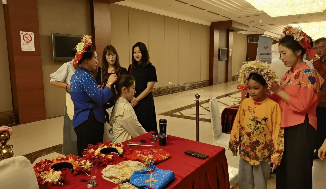 阿拉扎大學(xué)孔子學(xué)院志愿者老師向傳承人學(xué)習(xí)簪花圍。阿拉扎大學(xué)孔子學(xué)院供圖