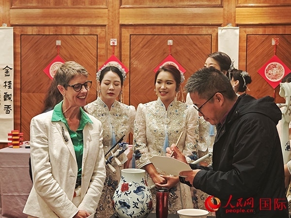 現(xiàn)場(chǎng)的非遺傳承人為英國觀眾展示畫技。人民網(wǎng)記者 邢雪攝