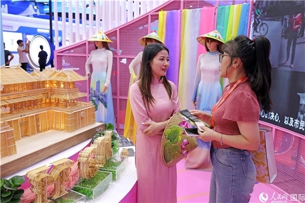 參觀者在東博會越南展區(qū)同工作人員咨詢交談。人民網(wǎng)記者 趙益普攝