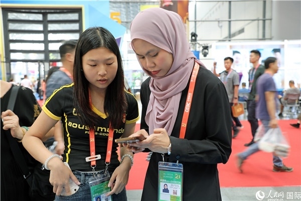 東博會現(xiàn)場，馬來西亞展商在同中方工作人員交談。人民網(wǎng)記者 趙益普攝