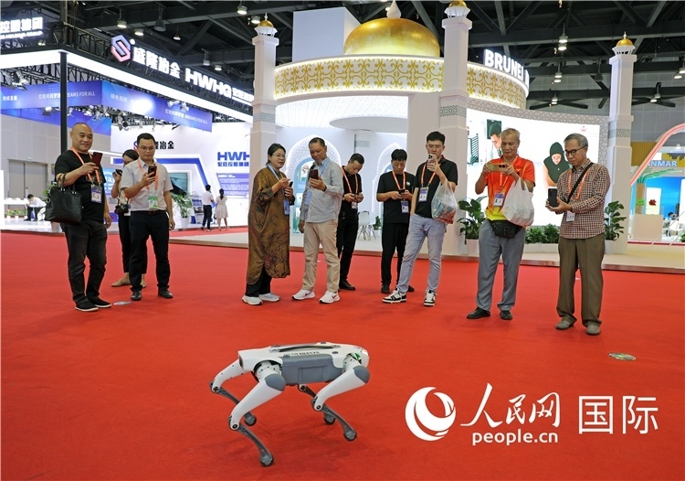 東博會(huì)上，觀眾正在參觀一只機(jī)器狗。綠色能源、新能源汽車、綠色農(nóng)產(chǎn)品等成為本屆東博會(huì)觀眾關(guān)注的焦點(diǎn)。人民網(wǎng)記者 趙益普攝