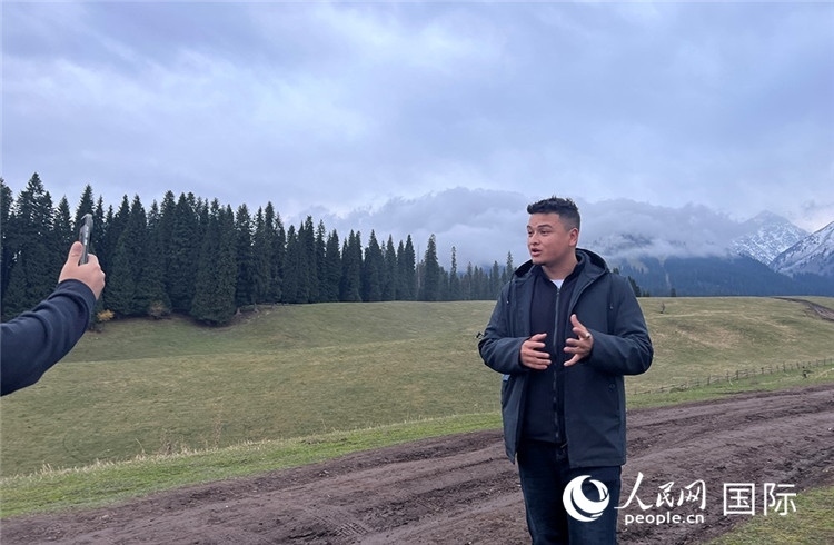 在庫(kù)爾德寧，吾買爾江被雪山美景震撼，即興錄制了短視頻作品。人民網(wǎng)記者曾書柔攝