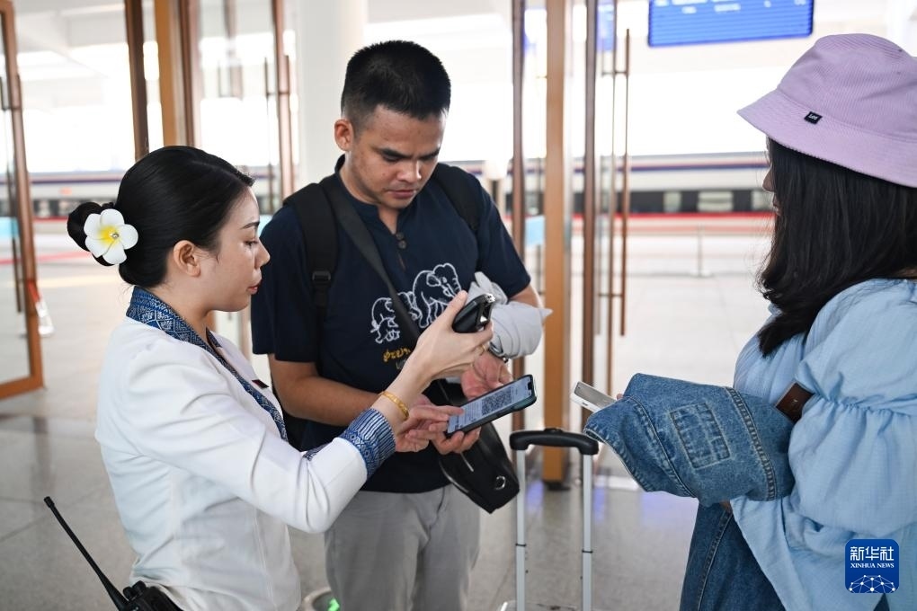 10月12日，在老撾萬象中老鐵路萬象站，工作人員檢驗乘客車票。新華社記者 程一恒 攝