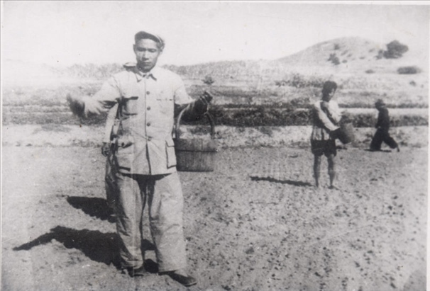 谷文昌（左）在田間與農(nóng)民一起勞動(dòng)（資料照片）。