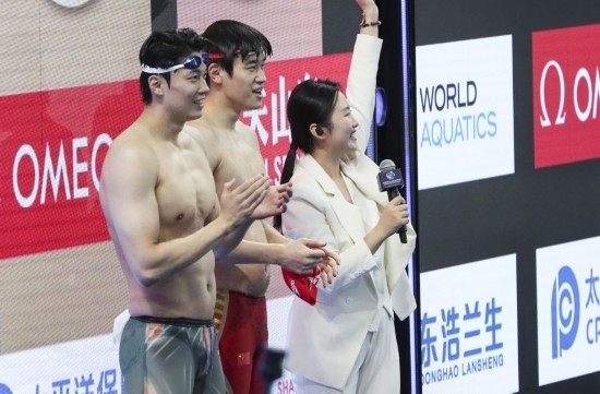  10月18日，汪順（左）和潘展樂在男子100米混合泳決賽后。新華社記者 方喆 攝