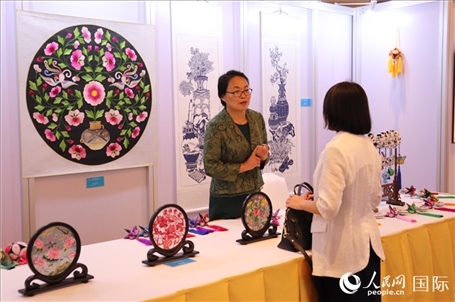 青海非遺文化傳承人向嘉賓介紹展品。人民網(wǎng)實習(xí)生姚欣可攝