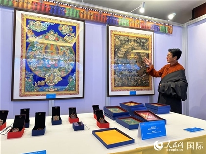 熱貢藝術(shù)國家級代表性傳承人夏吾角向嘉賓介紹作品。人民網(wǎng)記者 簡承淵攝