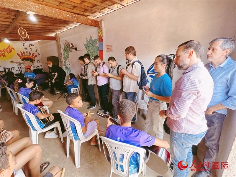  受益于中國企業(yè)的“青少年成長”項目，700多名當?shù)厍嗌倌甑囊魳泛妥闱驂粝氩迳狭顺岚?。圖為聯(lián)合采訪團正在采訪參加音樂培訓的孩子們。 人民網(wǎng)記者 陳一鳴攝