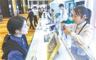 在北京麗澤商務(wù)區(qū)，工作人員（右一）介紹數(shù)字人民幣SIM卡硬錢包。新京報(bào)記者 陶冉攝