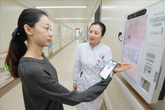 醫(yī)護(hù)人員引導(dǎo)患者在自助機(jī)前辦理自助入院手續(xù)。圖片來源：山東第一醫(yī)科大學(xué)第二附屬醫(yī)院