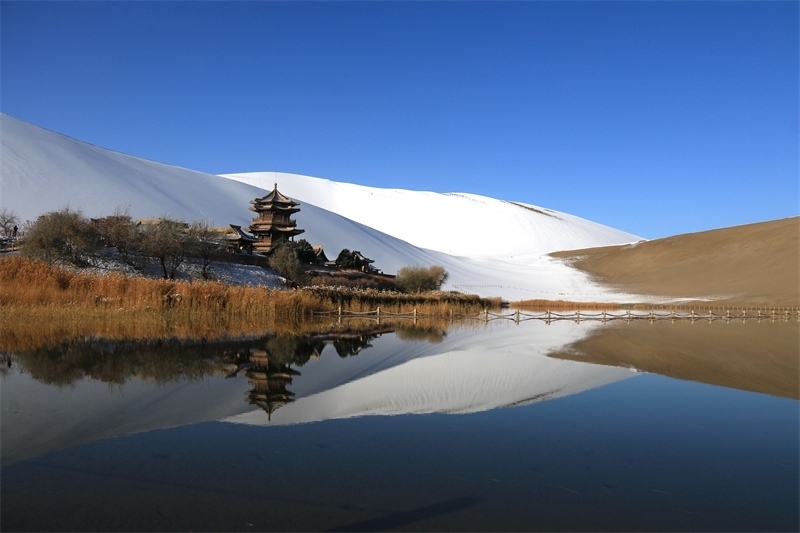 鳴沙山月牙泉景區(qū)雪景。敦煌市委宣傳部供圖，張曉亮攝