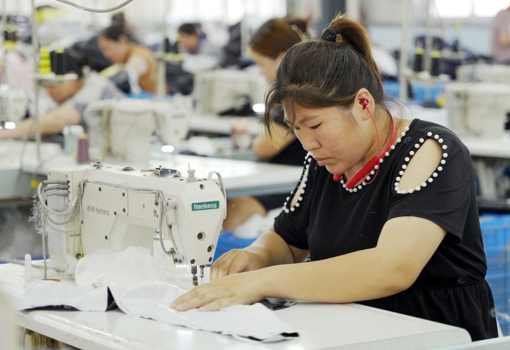 5月20日，村民在李寨村服裝加工廠內(nèi)忙碌。河南省周口市沈丘縣馮營鎮(zhèn)李寨村地處豫東平原。近年來，乘著脫貧攻堅(jiān)與鄉(xiāng)村振興政策的東風(fēng)，李寨村積極探索產(chǎn)業(yè)發(fā)展模式，通過“龍頭企業(yè)+村集體經(jīng)濟(jì)+農(nóng)戶”的方式，逐漸發(fā)展形成肉牛養(yǎng)殖、設(shè)施農(nóng)業(yè)、服裝加工、康養(yǎng)民宿等產(chǎn)業(yè)，以產(chǎn)業(yè)振興助力鄉(xiāng)村振興。新華社記者 李嘉南 攝