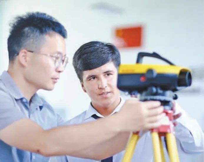 在塔吉克斯坦首都杜尚別的魯班工坊，來自天津城市建設(shè)管理職業(yè)技術(shù)學(xué)院的老師（左）為當(dāng)?shù)貙W(xué)生提供指導(dǎo)。新華社記者 鄭開君 攝