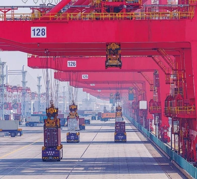 共建“一帶一路”國家在工作制度對接、技術(shù)標(biāo)準(zhǔn)協(xié)調(diào)、檢驗結(jié)果互認(rèn)等方面強(qiáng)化合作、統(tǒng)一標(biāo)準(zhǔn)，貿(mào)易自由化便利化水平不斷提升。上海洋山港海關(guān)對接共建國家進(jìn)出口貨物相關(guān)標(biāo)準(zhǔn)，推動通關(guān)一體化方式申報，提升通關(guān)效率。圖為無人駕駛的全自動導(dǎo)引車在洋山港穿梭往來，搬運集裝箱。王初 攝