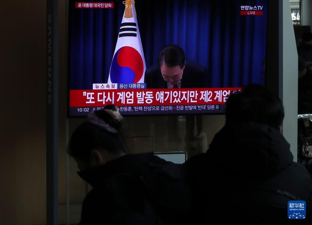 12月7日，在韓國(guó)首爾火車(chē)站，民眾觀看總統(tǒng)尹錫悅發(fā)表講話(huà)的電視畫(huà)面。新華社記者 姚琪琳 攝